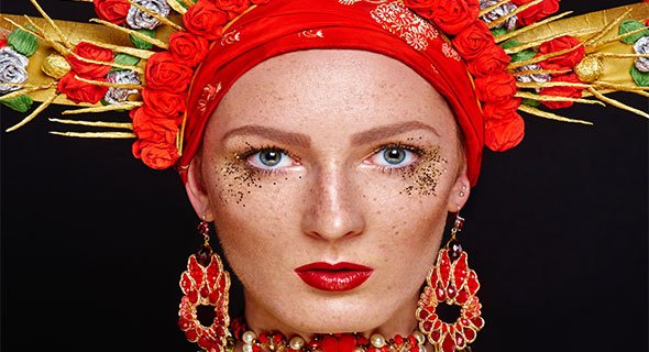 Portret kobiety w czerwonej kokosznikowej ozdobie z złotymi ornamentami i kolczykami
