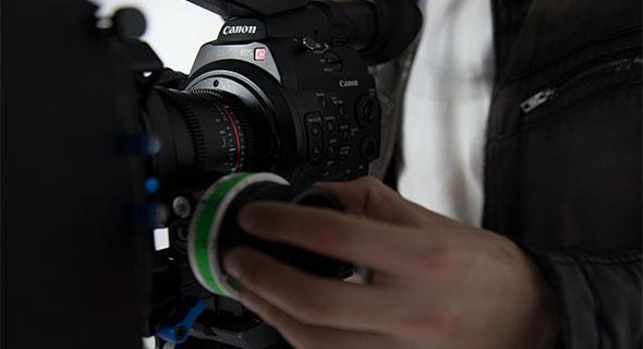 Operator trzyma profesjonalną kamerę Canon do filmowania i produkcji wideo