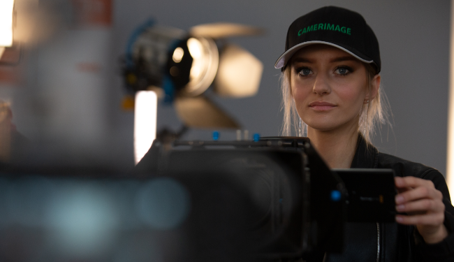 Kobieta operator filmu z kamerą profesjonalną podczas warsztatów operatorskich